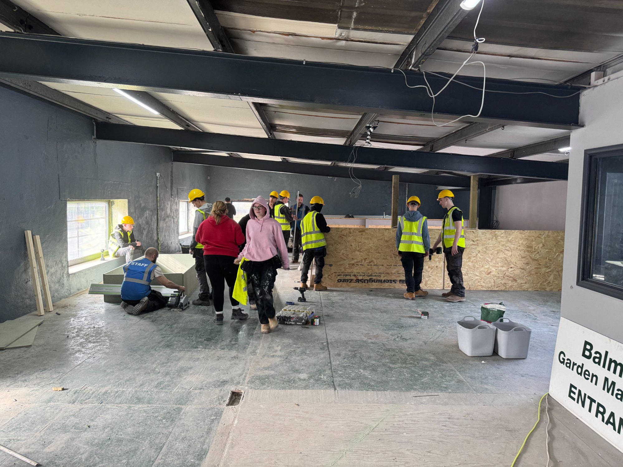 Volunteers painting with track lighting installed